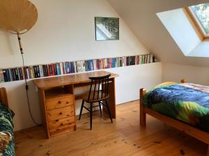a bedroom with a desk and a bed and a desk with books at La Petite Maison arc-en-ciel in La Feuillie