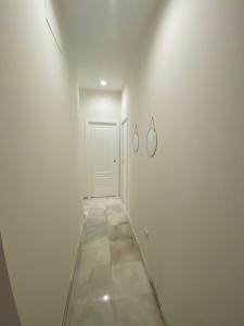 um corredor com uma porta branca e piso em azulejo em C Ciruelo 7 em Lora del Río