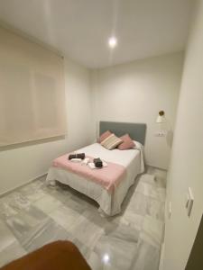 a bedroom with a bed with pink sheets and pink pillows at C Ciruelo 7 in Lora del Río