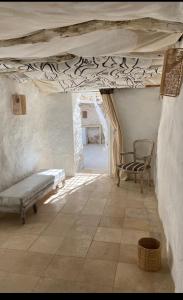 a room with a bed and a chair under a ceiling at Suite BELDI, La Maison des paons in Sidi Kaouki