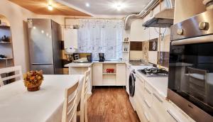 a large kitchen with white counters and a large window at Bota Apartments in Vulcan