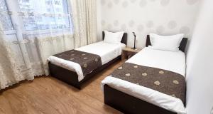 a bedroom with two beds and a window at Bota Apartments in Vulcan