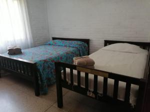 1 Schlafzimmer mit 2 Einzelbetten und einem Fenster in der Unterkunft Quinta Valentina Morelos in Temixco