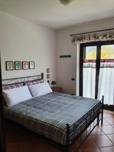a bedroom with a bed with a blue and green blanket at La Casetta di Margi in Ateleta