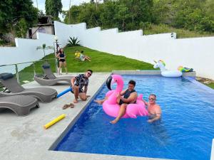 a group of people sitting on inflatables in a swimming pool at Check out this beautiful 5 bed villa with pool!! in Baclayon