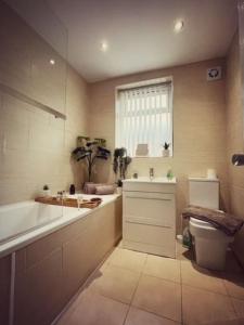 ein Badezimmer mit einer Badewanne, einem WC und einem Waschbecken in der Unterkunft Townhouse close to Liverpool City Centre - 5 bedrooms, Sleeps 9! in Liverpool