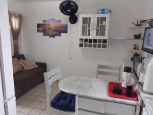 cocina y sala de estar con mesa y sofá en Condomínio Mar de Búzios en Nísia Floresta