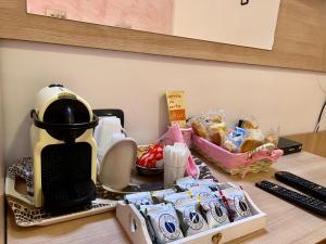 Agriturismo Le Essenze - Terrazza sulla Romagna في تشيسينا: وجود آلة صنع القهوة على طاولة مع الطعام