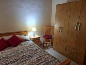 a bedroom with a bed and a large wooden cabinet at Colorina - El Nihuil in El Nihuil +5 photos