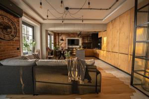 a living room with a couch and a kitchen at Industrial Apartment "I loft Opole" in Opole
