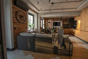 a living room with a couch and a brick wall at Industrial Apartment "I loft Opole" in Opole