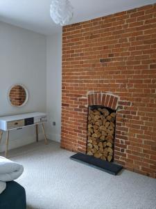 a brick fireplace with a pile of fire wood at Beautiful Georgian townhouse in central Colchester in Colchester