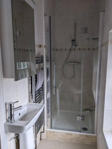 La salle de bains est pourvue d'une douche et d'un lavabo. dans l'établissement Beautiful Georgian townhouse in central Colchester, à Colchester