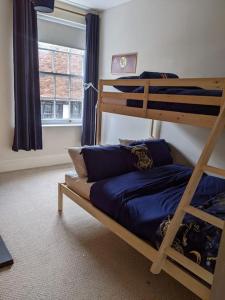 a bedroom with two bunk beds and a window at Beautiful Georgian townhouse in central Colchester in Colchester