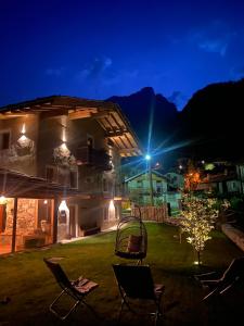 a yard with chairs and a house at night at Il Casias in Balme