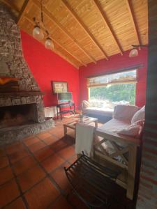 Cette chambre rouge comprend un lit et une cheminée. dans l'établissement Quinta Ecuador Tandil, à Tandil