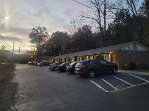 un gruppo di auto parcheggiate in un parcheggio di Economy Inn Sylva a Sylva