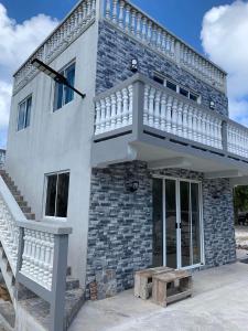 Una casa blanca con una escalera en el lateral. en Chez Guy , vue sur l'océan en Tiputa