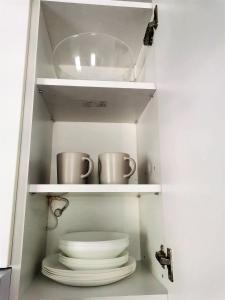 um armário com duas canecas e uma pilha de pratos em Kod Dede Brzece em Brzeće