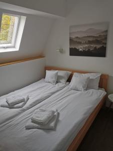 uma grande cama branca com duas toalhas sobre ela em Kod Dede Brzece em Brzeće