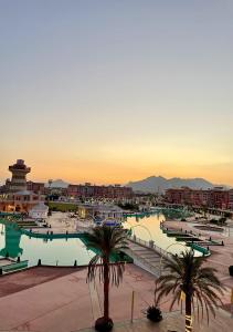 a large swimming pool with palm trees in a city at Fully Equipped Apartments Pool & Mountains View in Porto Sharm Resort in Sharm El Sheikh