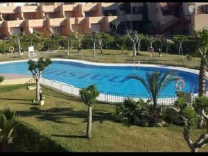 einem großen Pool mit Palmen vor einem Gebäude in der Unterkunft SUNRISE Vera-naturista in Vera