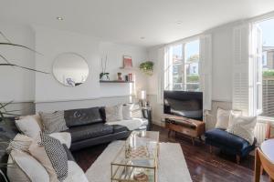 ein Wohnzimmer mit einem Sofa und einem Tisch in der Unterkunft The Dalston Maisonette in London