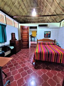 ein Schlafzimmer mit einem Bett und einem Tisch in einem Zimmer in der Unterkunft Maya Mountain Lodge in San Ignacio