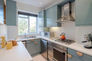 a kitchen with blue cabinets and a sink at The Dalston Maisonette in London