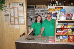 a man and a woman standing at a counter in a store at Letní rekreační středisko Schiffler Miroslav in Samopše