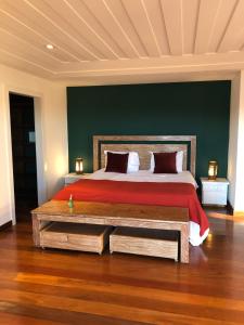 a bedroom with a large bed with a red bedspread at FERRADURA EXCLUSIVE SEaVIEW in Búzios