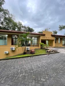 a house with a brick driveway in front of it at Private 5 Bedroom Home with Pool! in Tarcoles