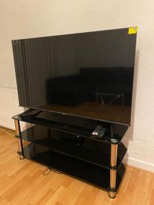 a flat screen tv sitting on a entertainment center at 3 bedroom home-inverkeithing in Fife