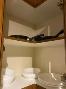 a shelf with three white plates and bowls on it at 3 bedroom home-inverkeithing in Fife