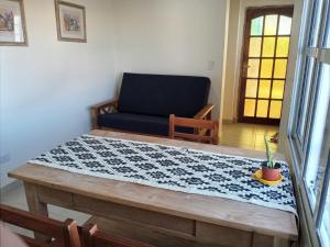 ein Wohnzimmer mit einem Tisch und einem Stuhl in der Unterkunft El Boulevard in Viedma
