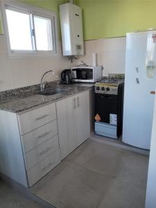 eine Küche mit einer Spüle und einem weißen Kühlschrank in der Unterkunft El Boulevard in Viedma