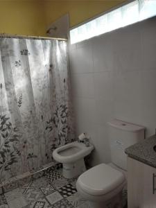 a bathroom with a toilet and a shower curtain at El Boulevard in Viedma