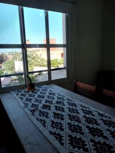 a bedroom with a bed and a window with a view at El Boulevard in Viedma