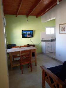 ein Wohnzimmer mit einem Tisch und einem TV an der Wand in der Unterkunft El Boulevard in Viedma