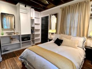 a bedroom with a large white bed and a window at Archaic Outhouse in Santee