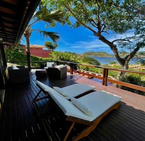 una terrazza con tavolo, sedie e vista sull'oceano di FERRADURA EXCLUSIVE SEaVIEW a Búzios