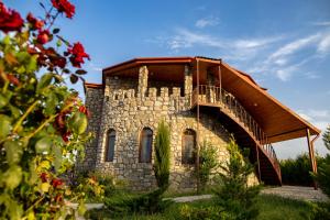 a stone building with a staircase on top of it at Chateau White Flags შატო თეთრი ბაირაღები in Kisiskhevi