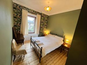 - une chambre avec un lit, une fenêtre et une chaise dans l'établissement Victorian apartment, central location with free parking., à Perth
