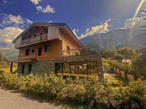 Cette maison en bois dispose d'un balcon au sommet d'une colline. dans l'établissement Chalet Amour blanc, aux Houches