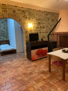 - un salon avec un mur en pierre et une table dans l'établissement Casale in collina vista Assisi,Brufa di Torgiano, à Brufa