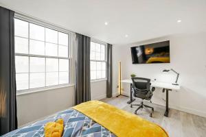 - une chambre avec un bureau et un lit dans l'établissement Modern 2 bedroom apartment in the heart of London, à Londres