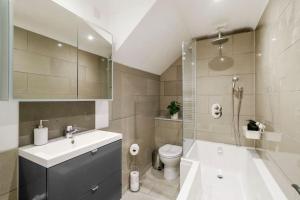 y baño con lavabo, aseo y ducha. en Modern 2 bedroom apartment in the heart of London, en Londres