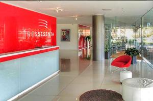 a restaurant with a red wall and a red chair at Torre Tressesenta Apto 1508 in Punta del Este