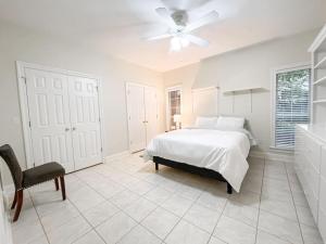um quarto branco com uma cama e uma ventoinha de tecto em Spacious King Suite Mid Town Home With Serene Patio em Hattiesburg