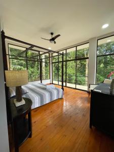 1 dormitorio con 1 cama y un montón de ventanas en Private 5 Bedroom Home with Pool!, en Tarcoles